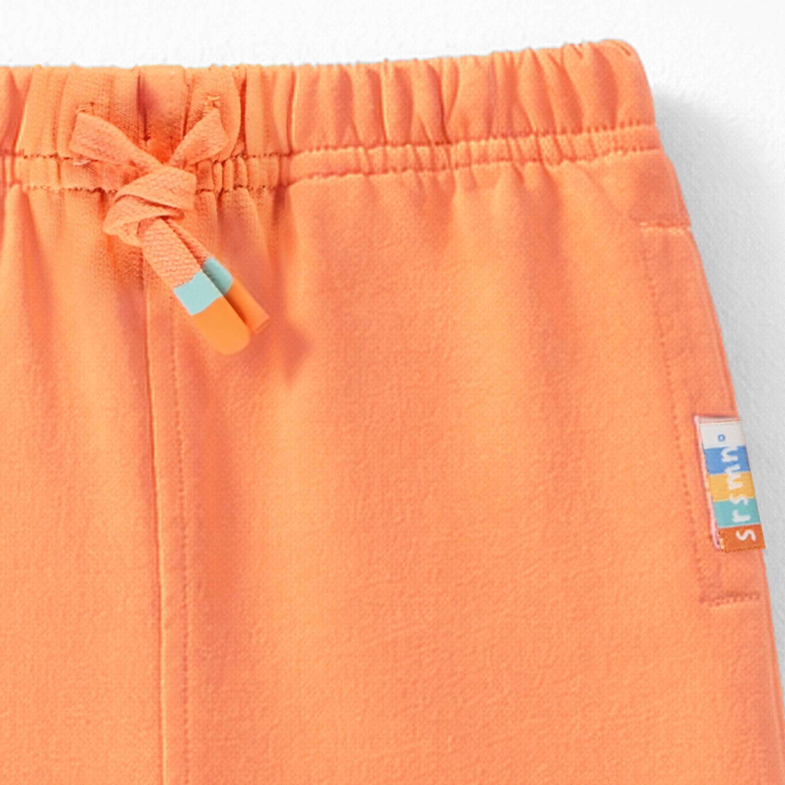 Zoom détails du dos du pantalon orange style jogger, bébé 