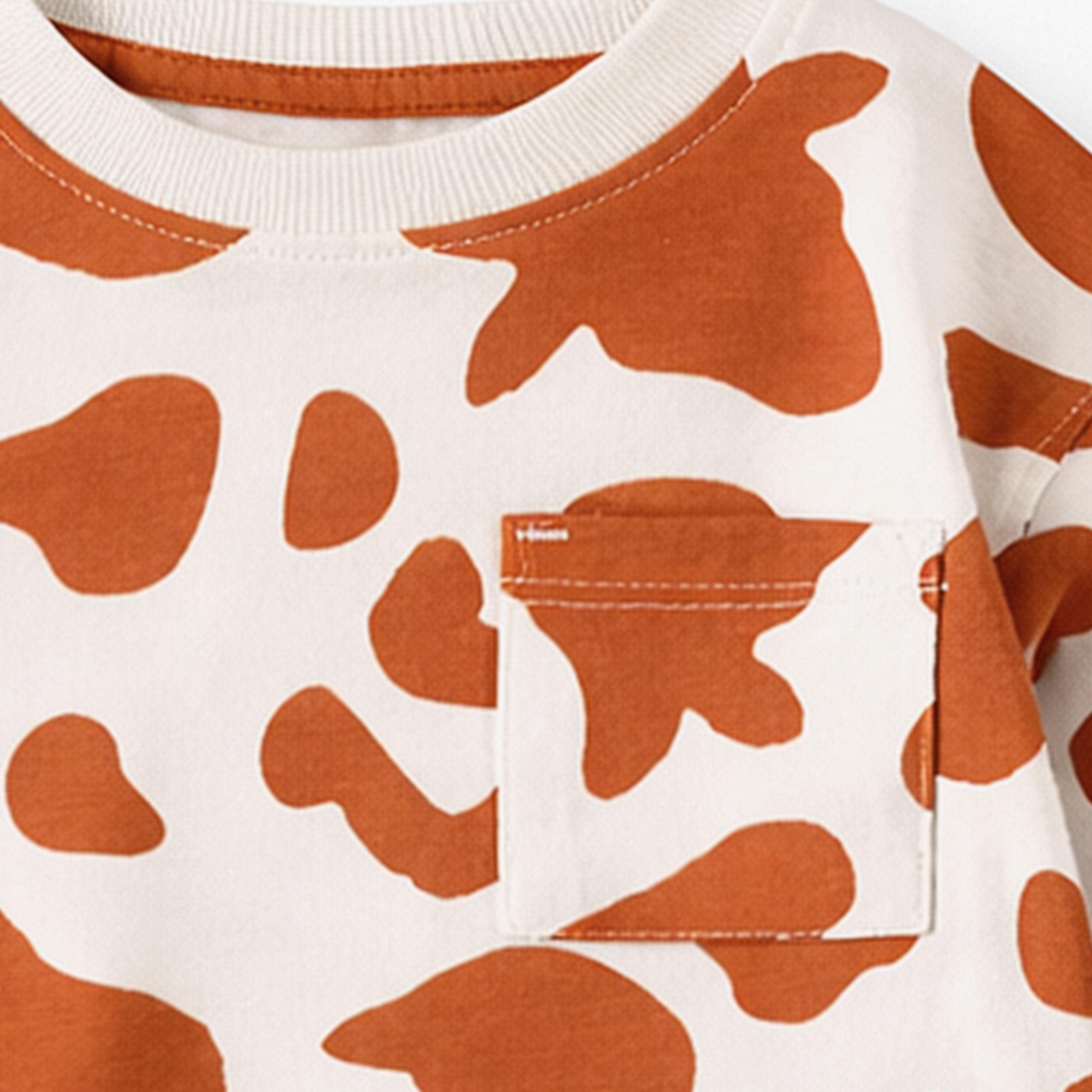 Zoom détails du t-shirt crème et brun avec motif de vache, bébé