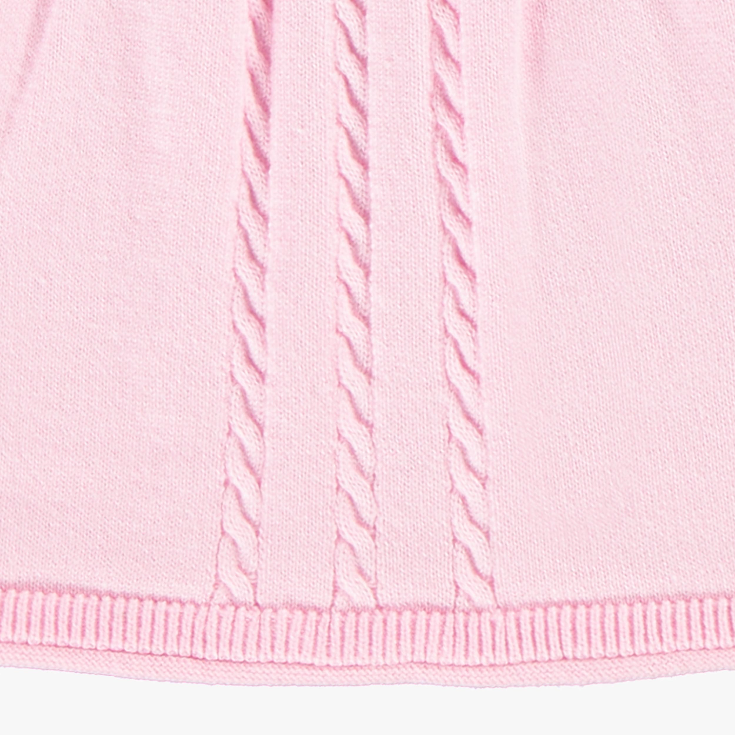Zoom détails torsade de la robe rose en tricot, bébé