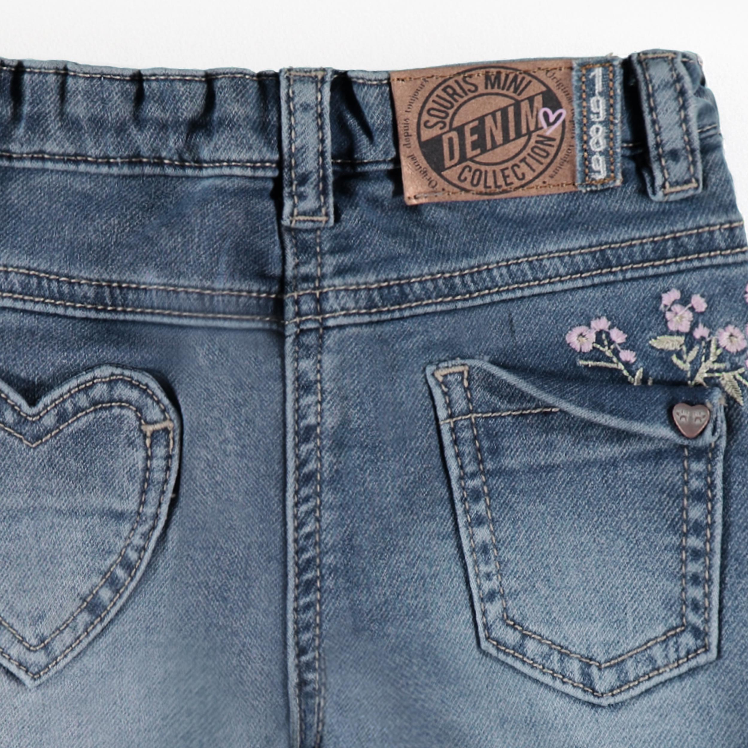 Zoom dos du jean bleu avec broderies florales, bébé