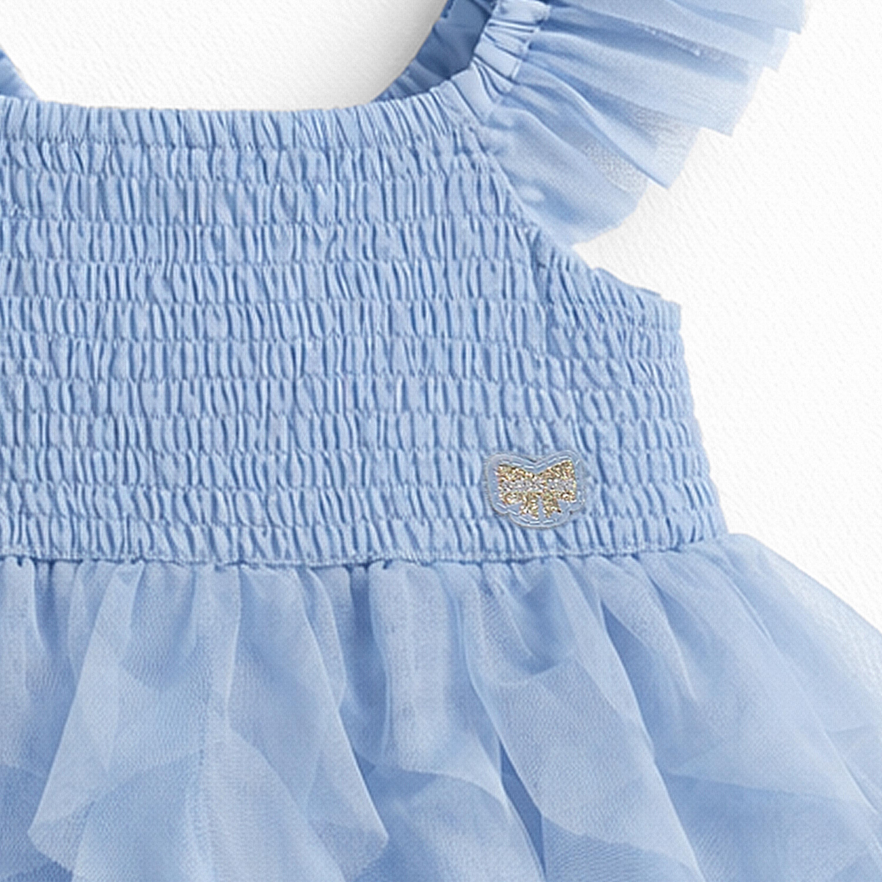 Zoom du nid abeille de la robe bleue en tulle souple, bébé