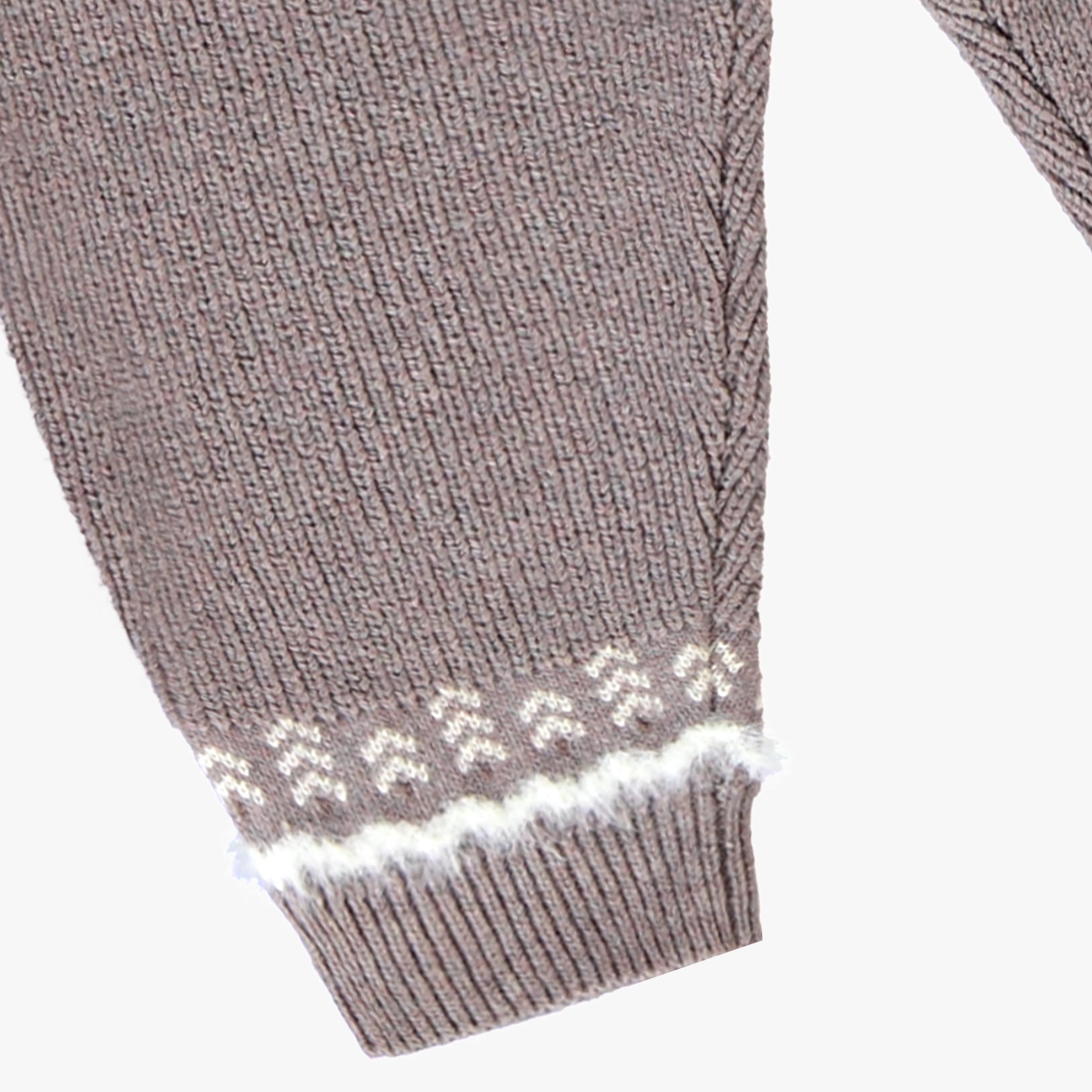 Gros plan sur le bas de jambe du pantalon en tricot gris mauve pour bebe garcon avec cheville cotelee et motif jacquard blanc.