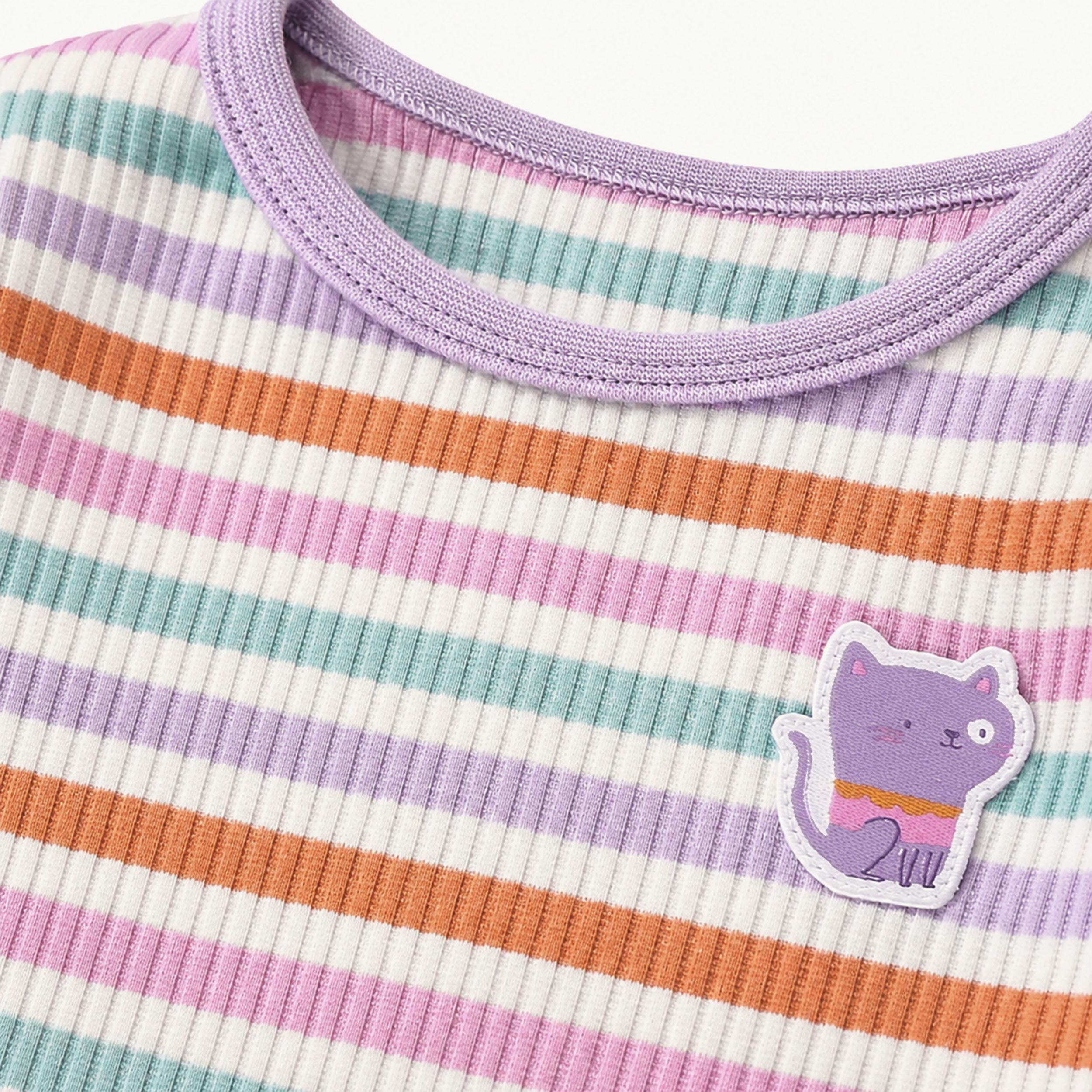 Gros plan d'un pyjama pour enfant a rayures multicolores avec col lilas et ecusson chat violet.