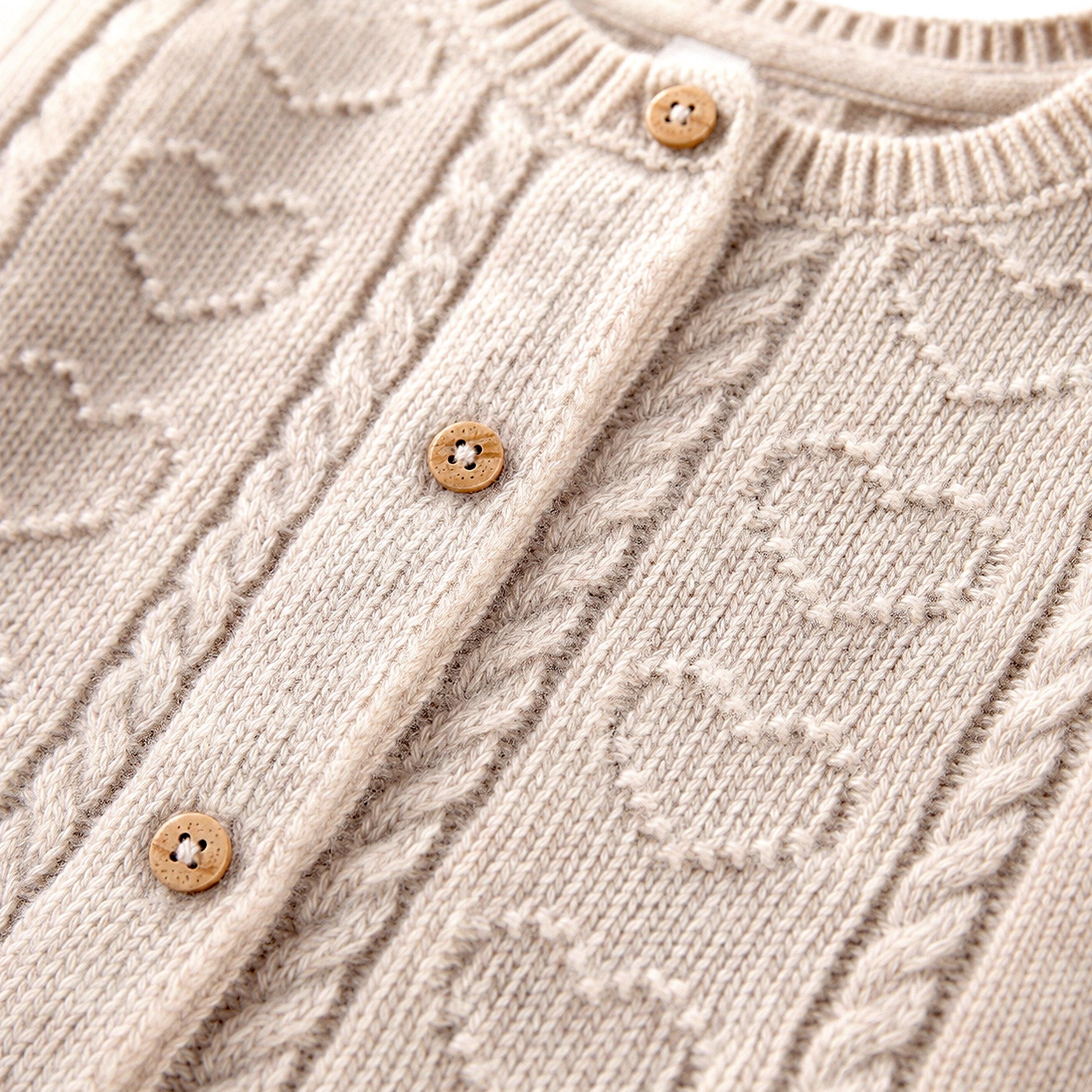 Zoom de la veste crème en tricot, naissance 