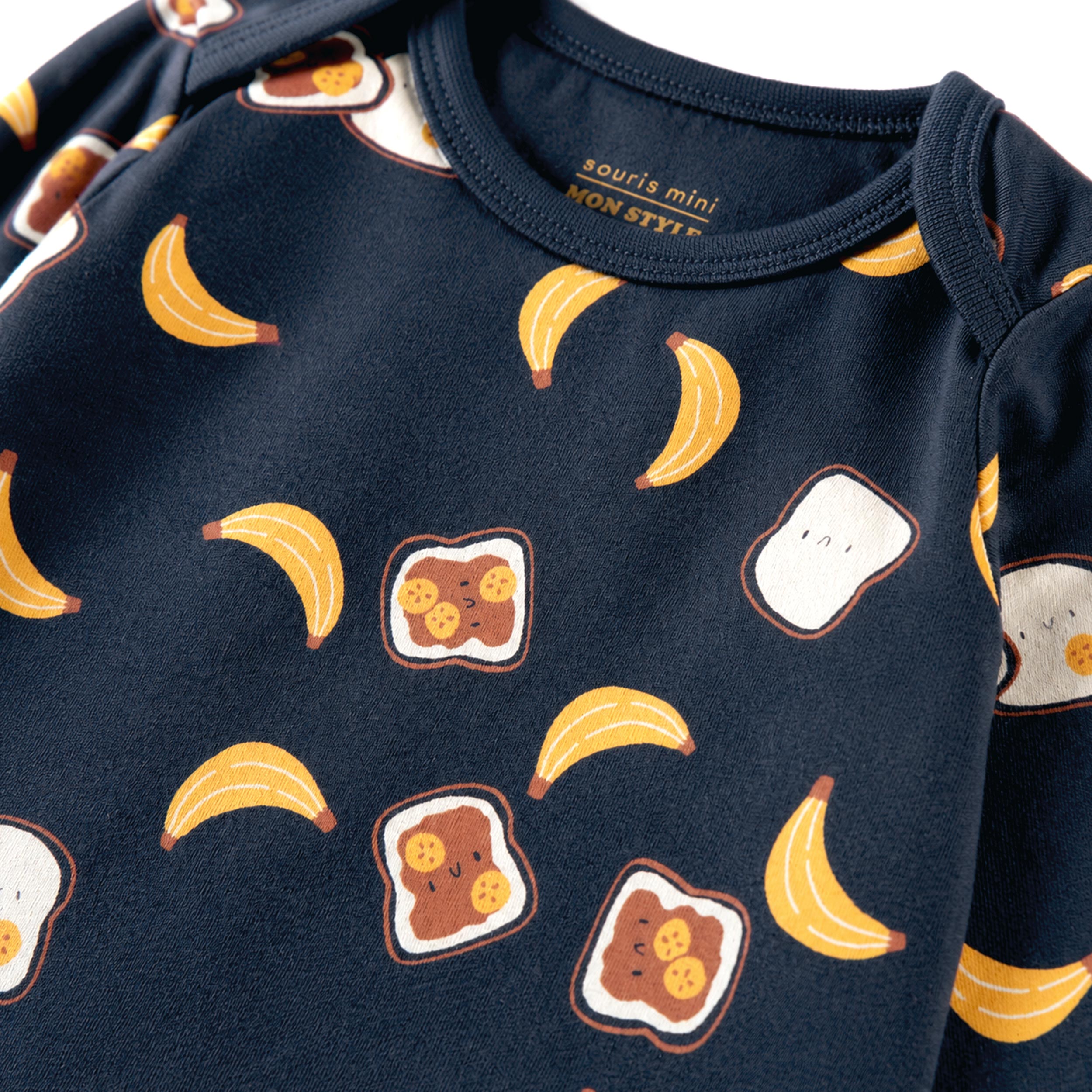 Zoom détails du cache-couche bleu foncé à imprimé de tartines et bananes, bébé