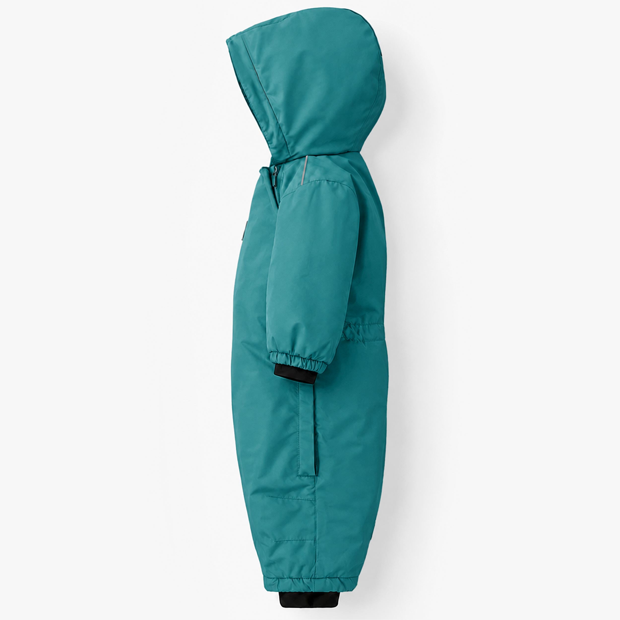 Vue de profil d’une combinaison de neige une pièce pour bébé turquoise avec capuchon protecteur, poignets coupe-froid et coupe adaptée aux activités hivernales.