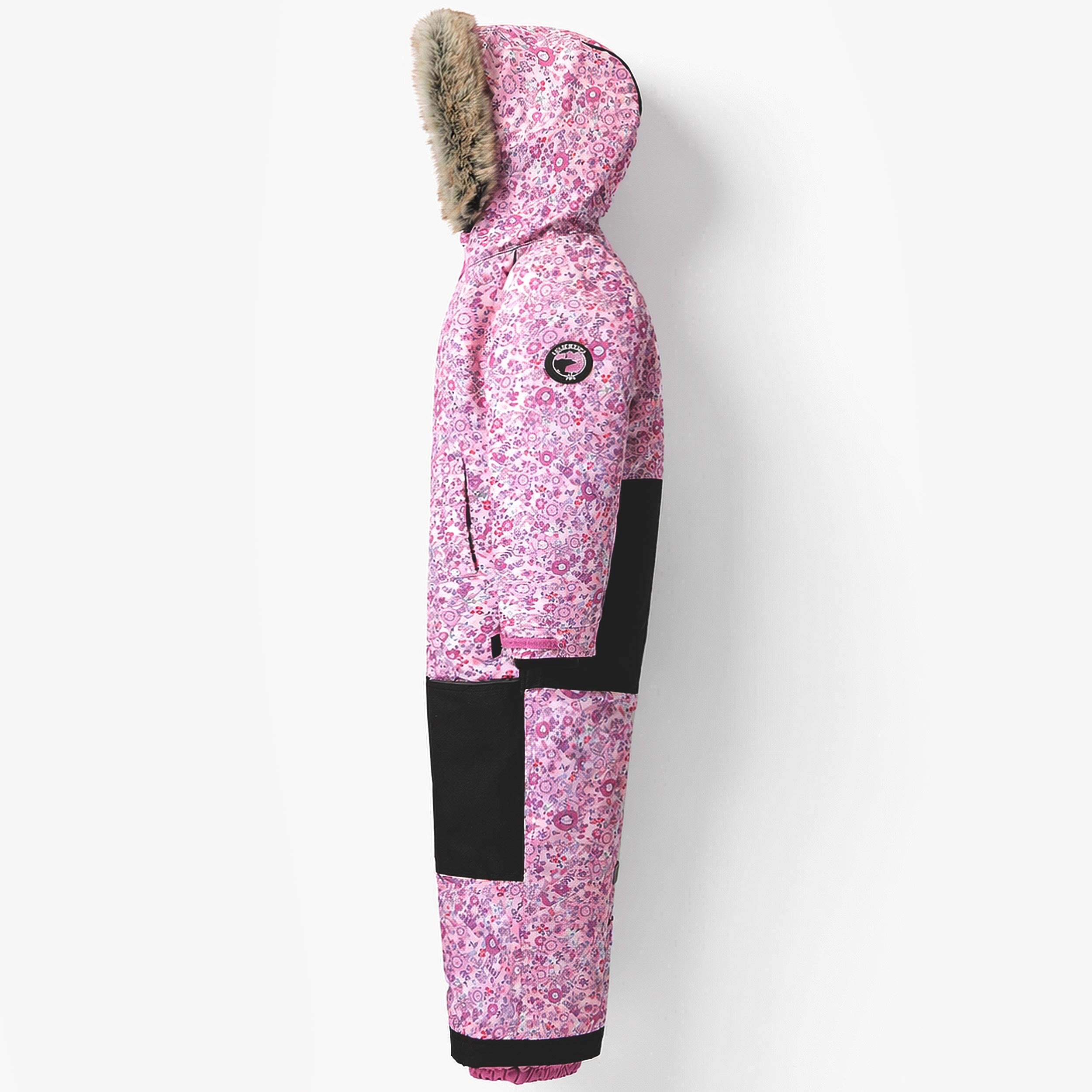 Vue de profil de la combinaison de neige enfant rose à imprimé floral avec capuche bordée de fausse fourrure.