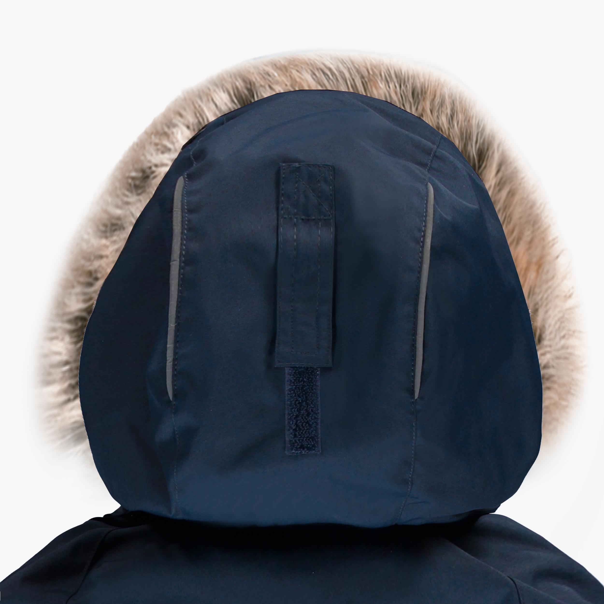 Détail du capuchon de combinaison de neige pour enfant bleu marine avec garniture en fausse fourrure, bandes réfléchissantes et attache arrière.