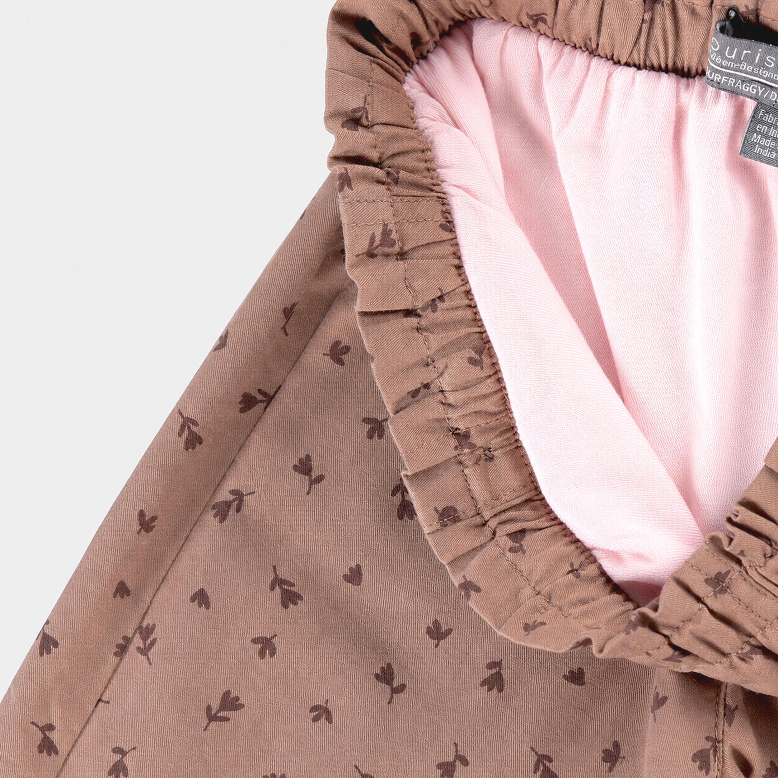Zoom sur la doublure intérieure rose d’un pantalon bébé à imprimé floral avec taille élastique