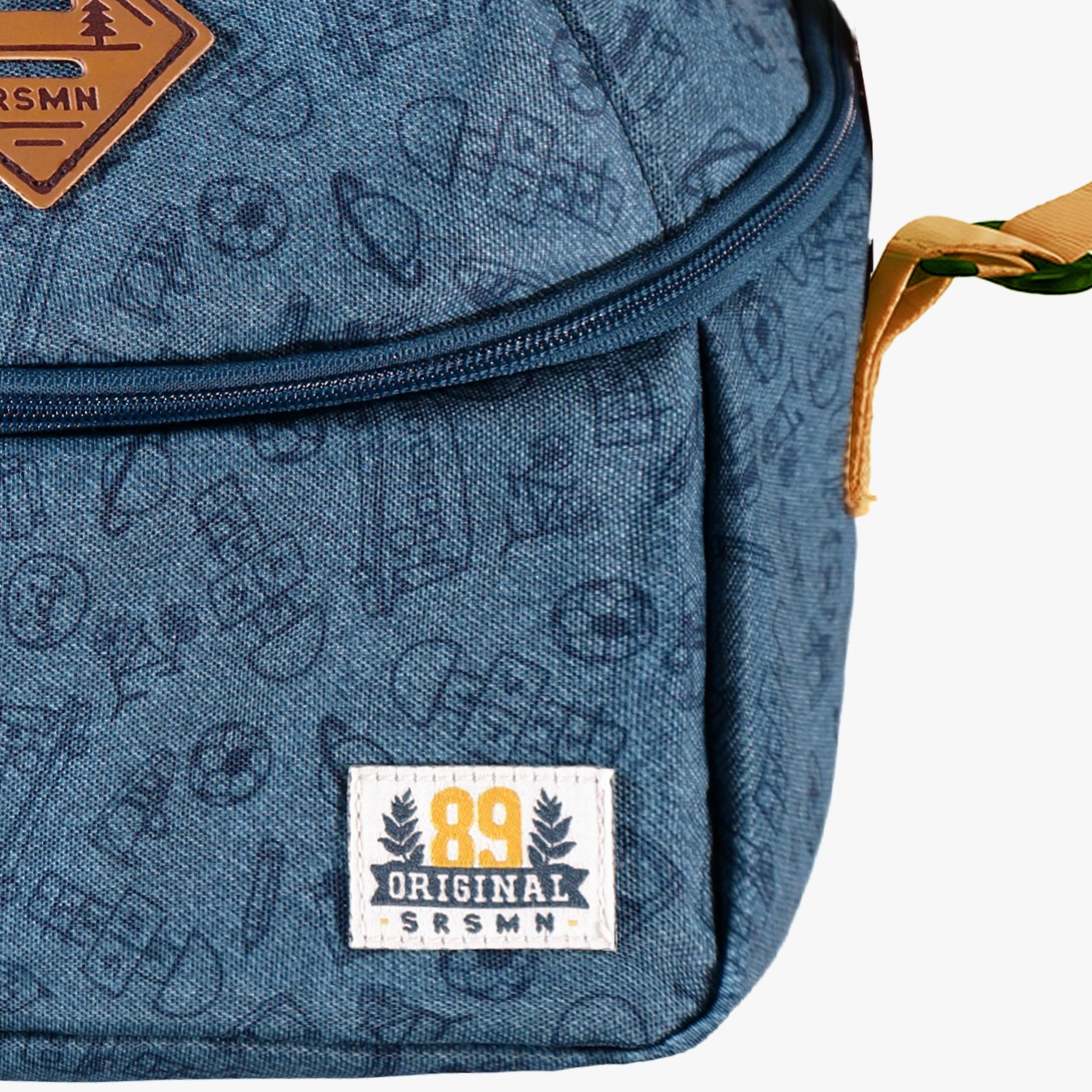 Gros plan sur le tissu bleu à motif sport et les finitions d’un sac isotherme enfant.