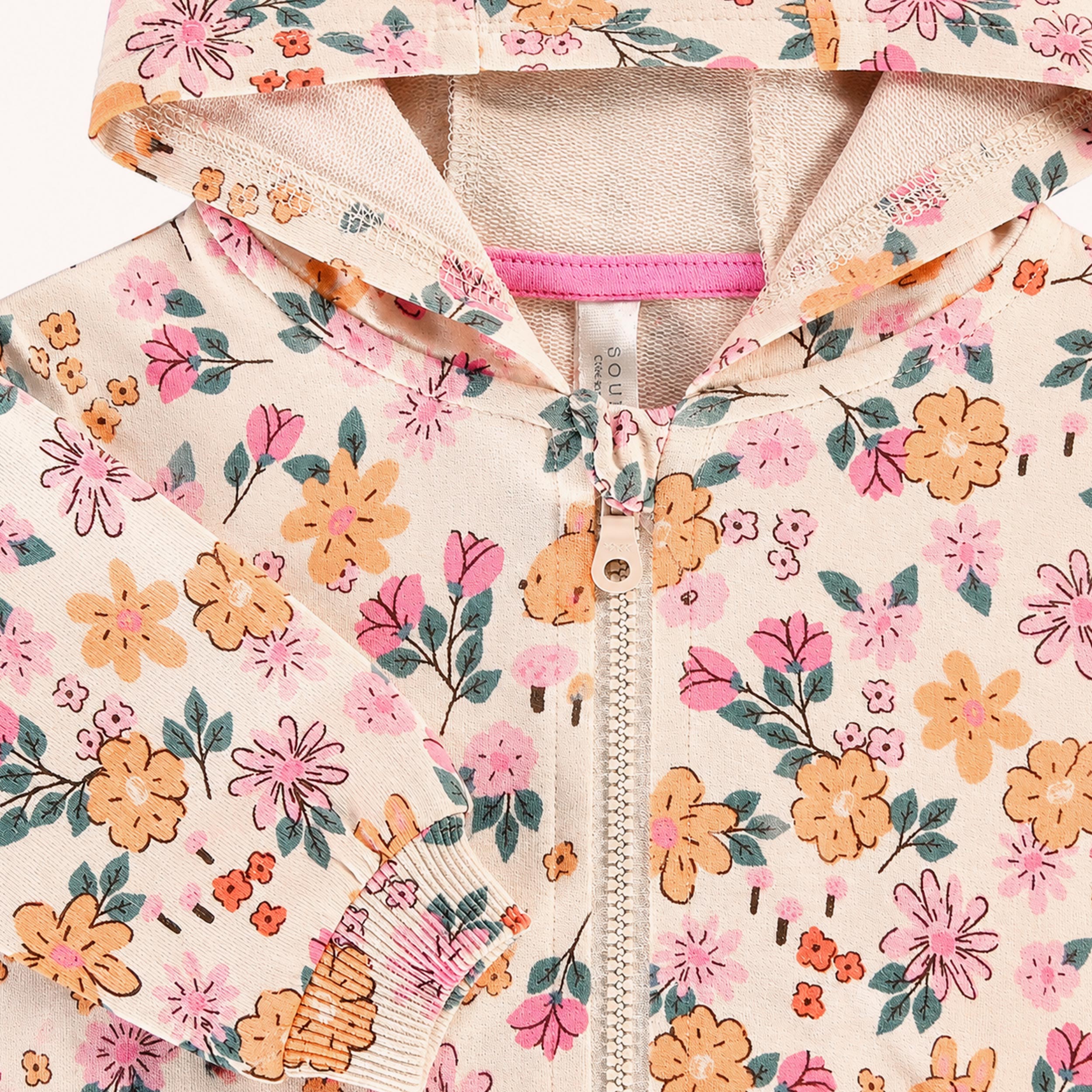 Gros plan sur la veste à capuche bébé fille avec imprimé floral multicolore et fermeture zippée.