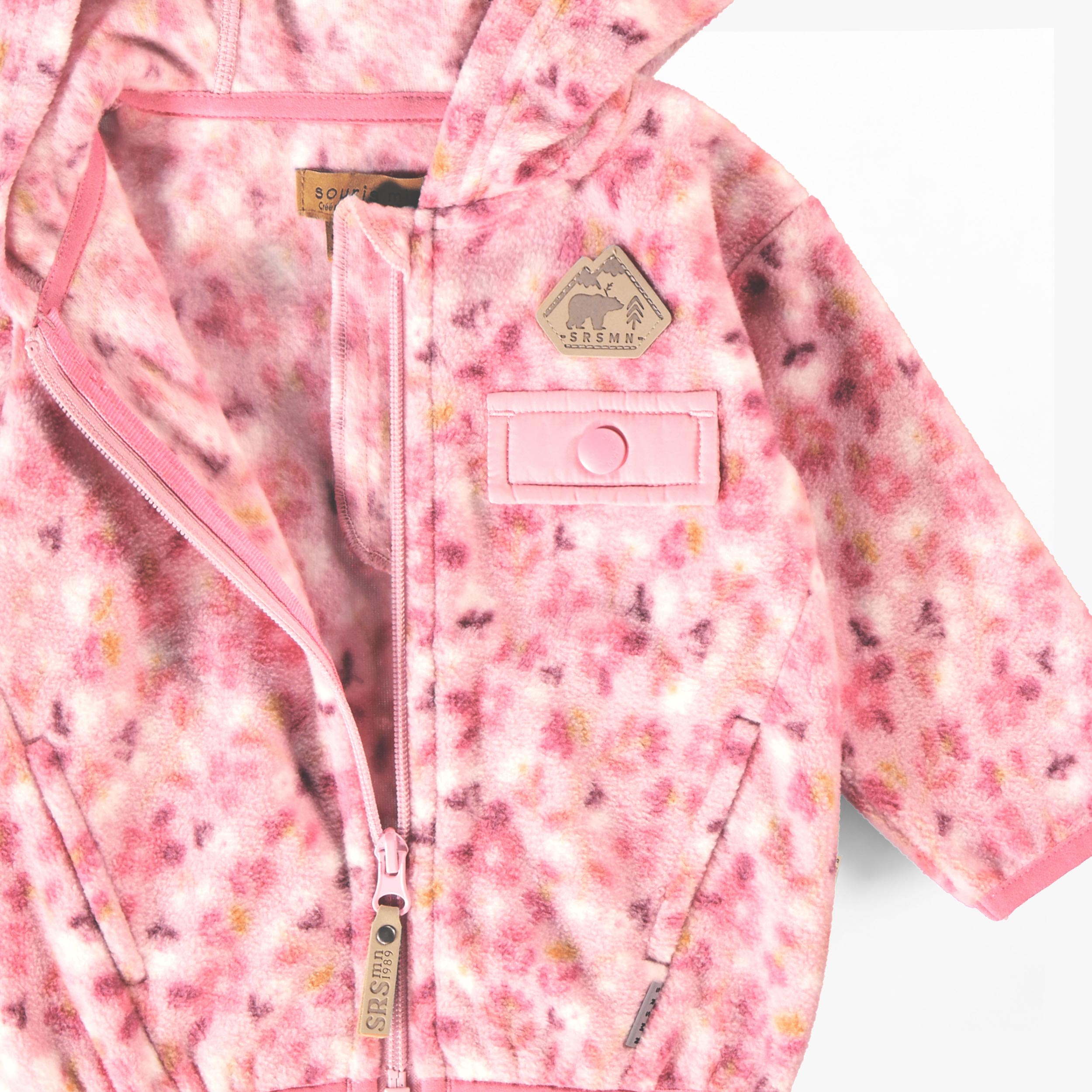 Détail de la fermeture éclair et de l'intérieur en polar de la veste rose à imprimé floral pour bébé.