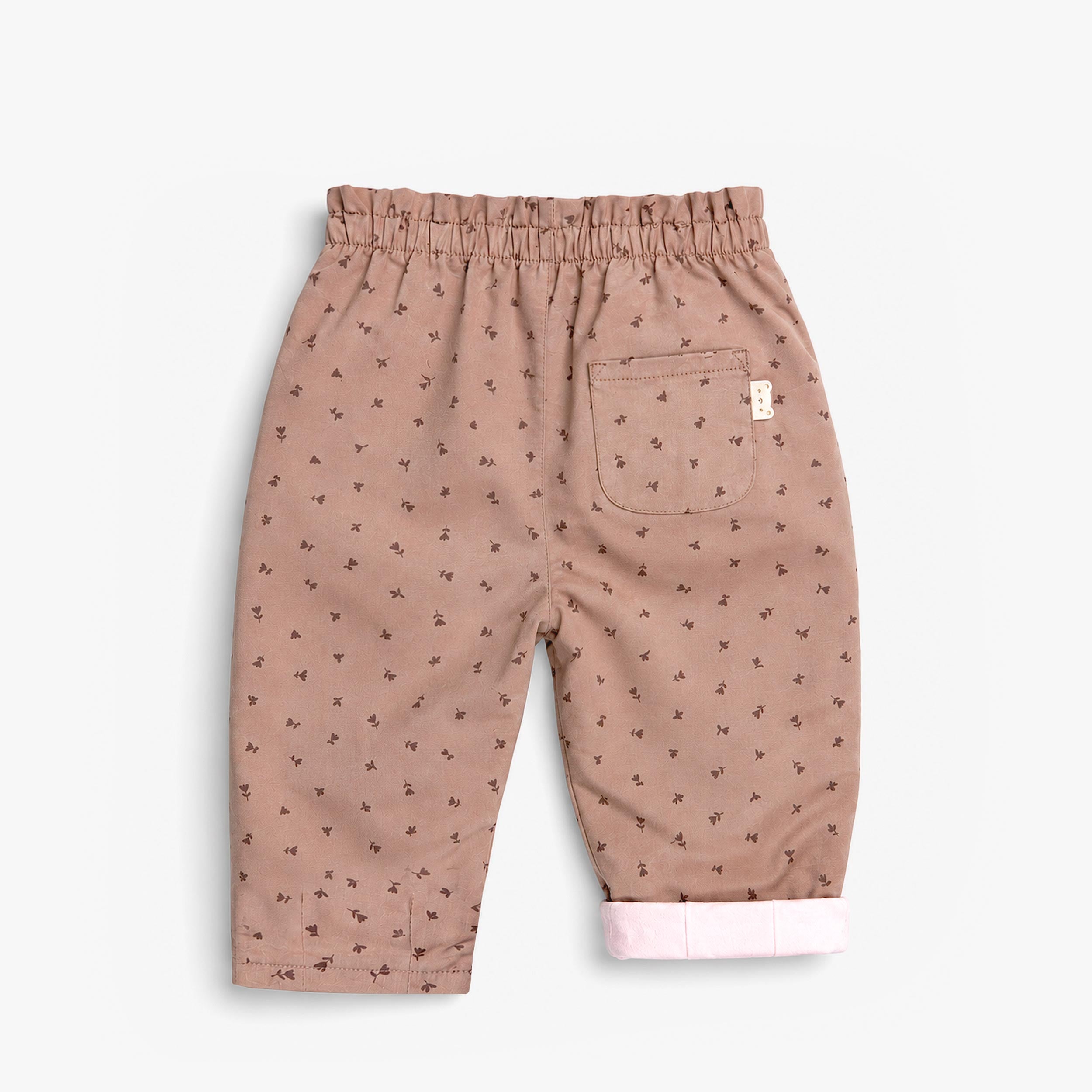Vue arrière d’un pantalon bébé rose poudré à imprimé floral avec poche arrière et taille élastique