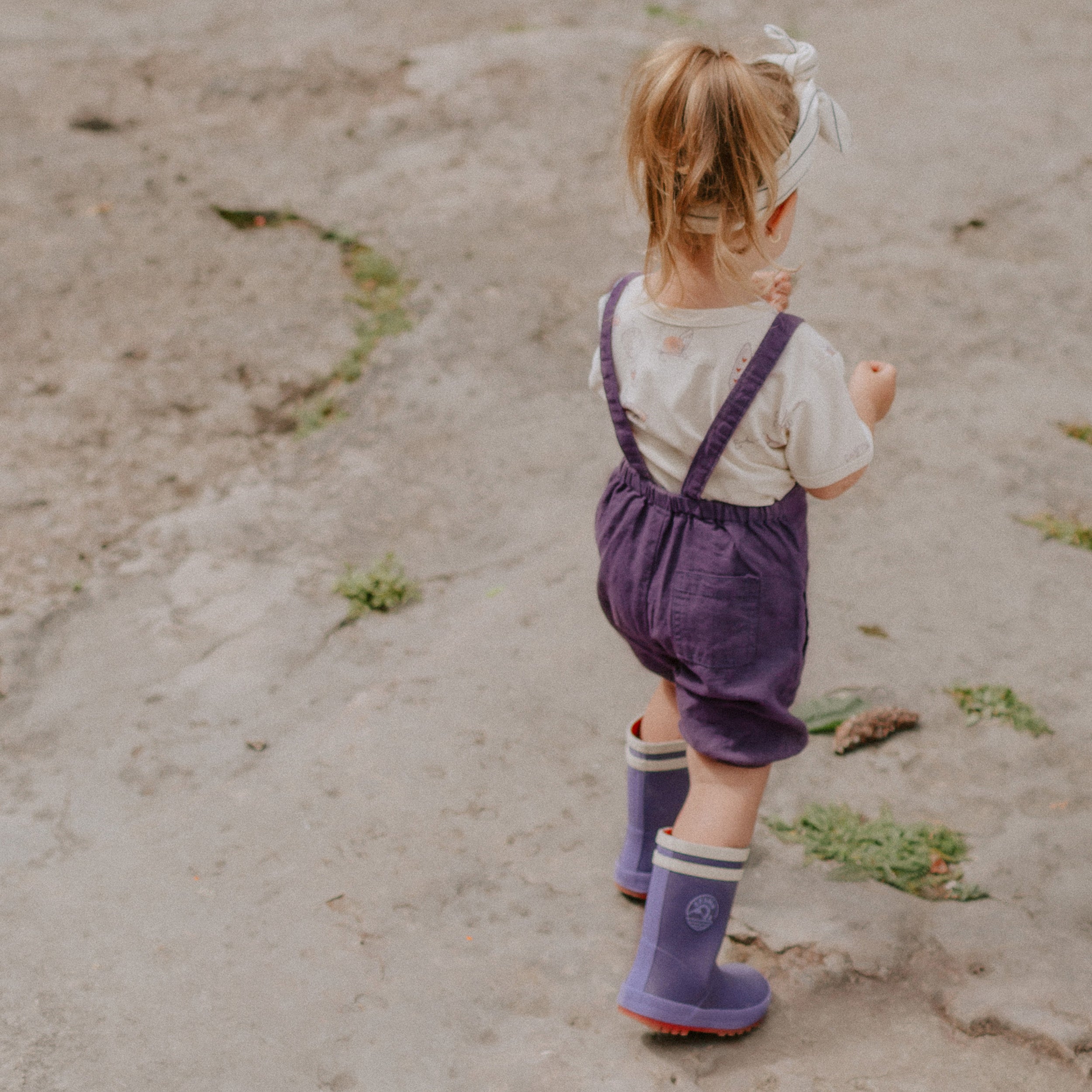 Photo d'un bébé portant la salopette mauve ample en lin, bébé
