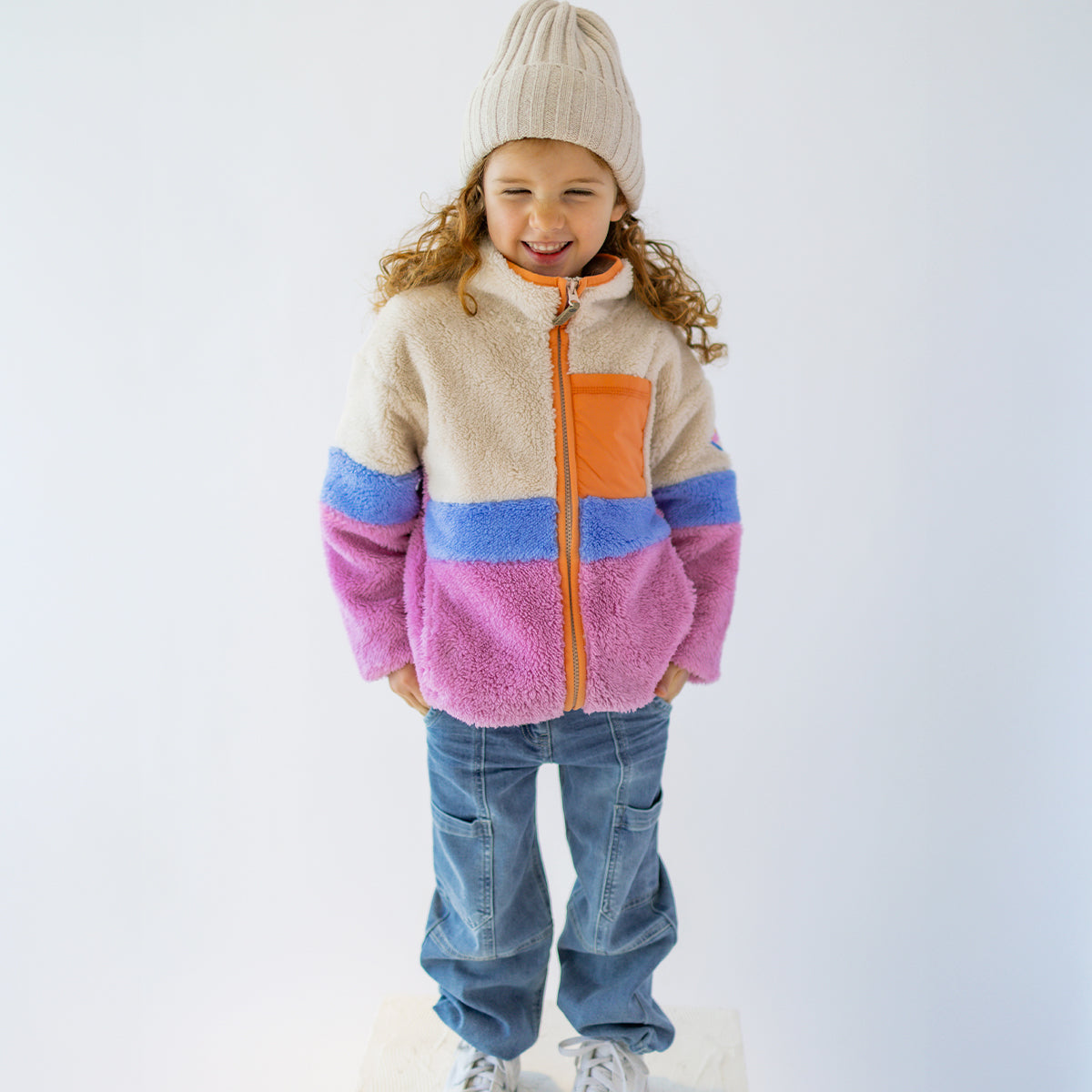 Enfant portant une polaire Souris Mini rose, mauve et crème avec fermeture éclair et poche contrastée.