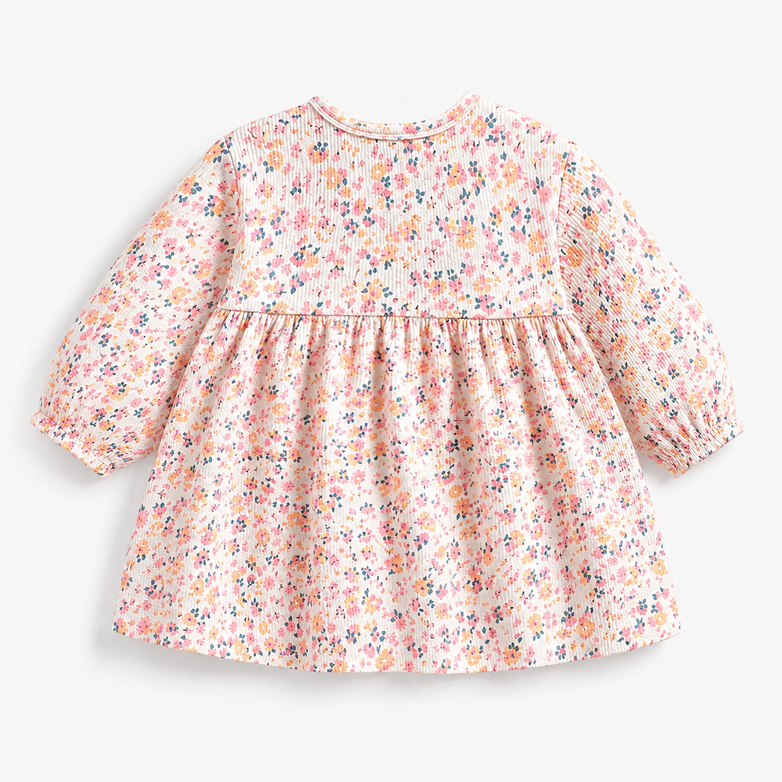Dos d’une robe bébé fille à manches longues avec imprimé floral multicolore sur fond clair.