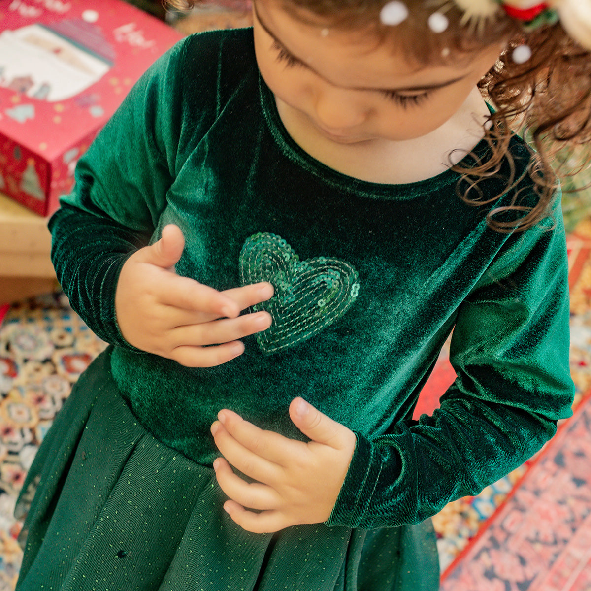 Fillette portant une robe verte en velours avec un cœur scintillant en paillettes, parfaite pour les célébrations de Noël, collection Souris Mini.