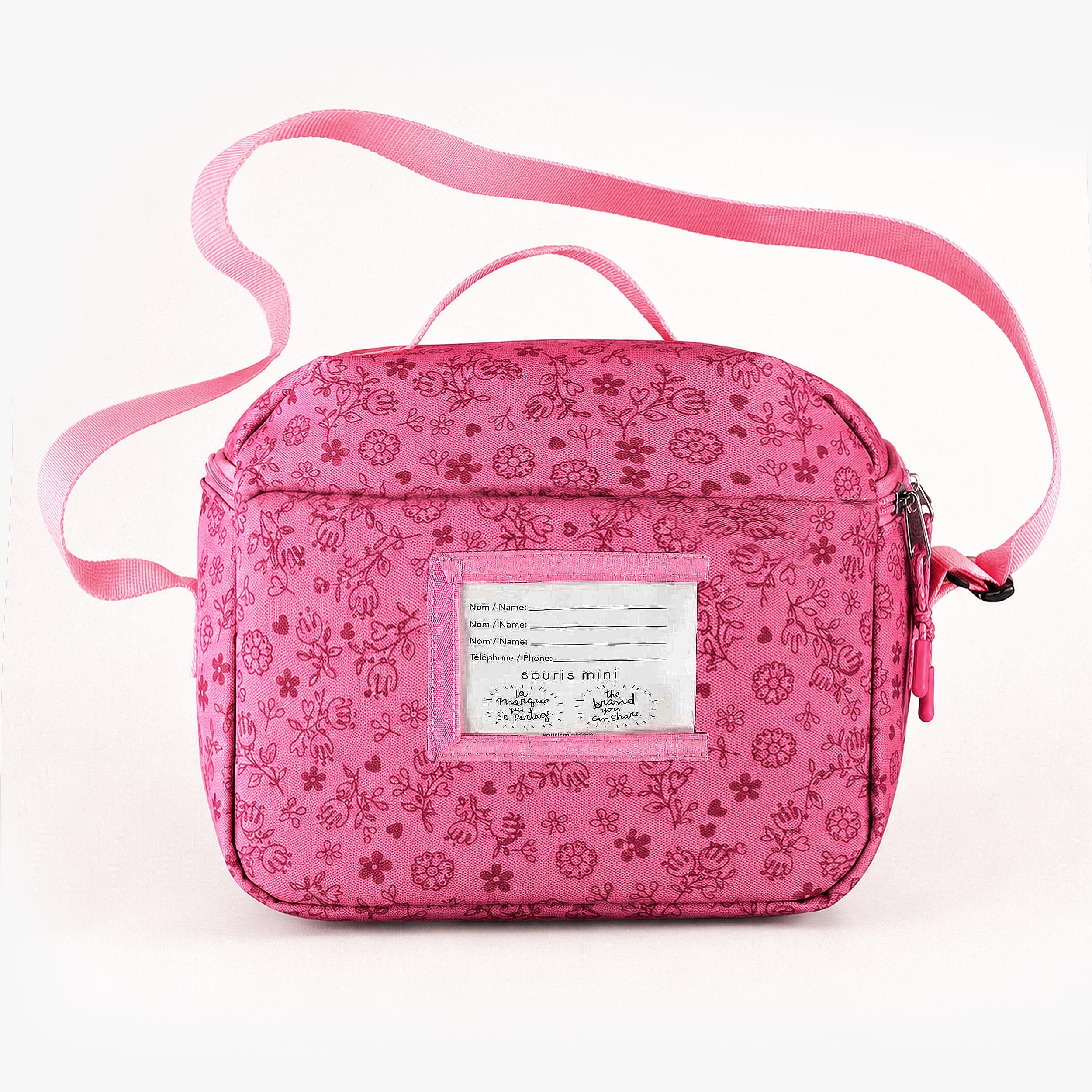 Vue arrière d’un sac isotherme enfant rose à imprimé floral avec bandoulière réglable et porte-étiquette transparent.