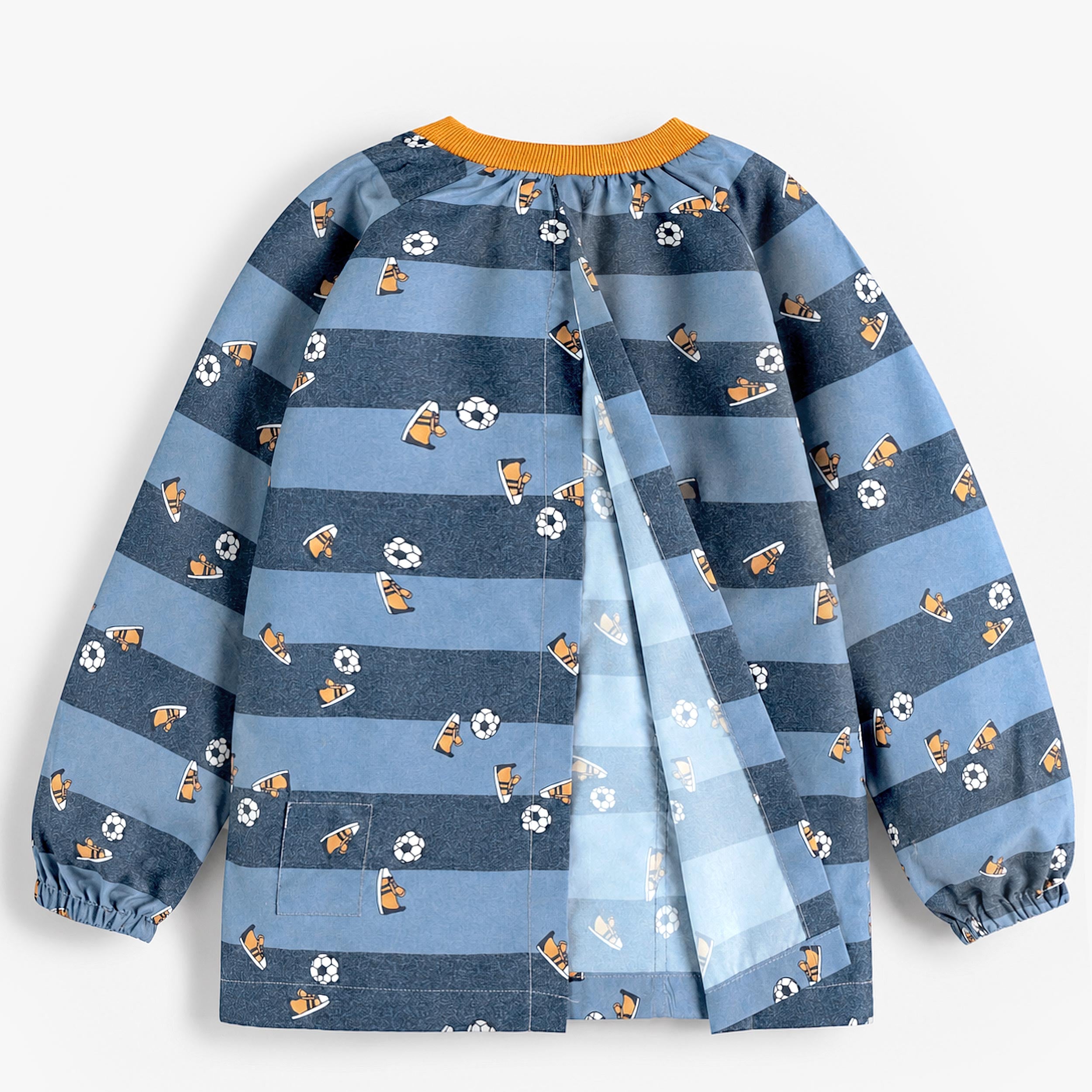 Vue arrière d’un tablier enfant bleu à manches longues avec motifs football et baskets, ouverture croisée dans le dos.