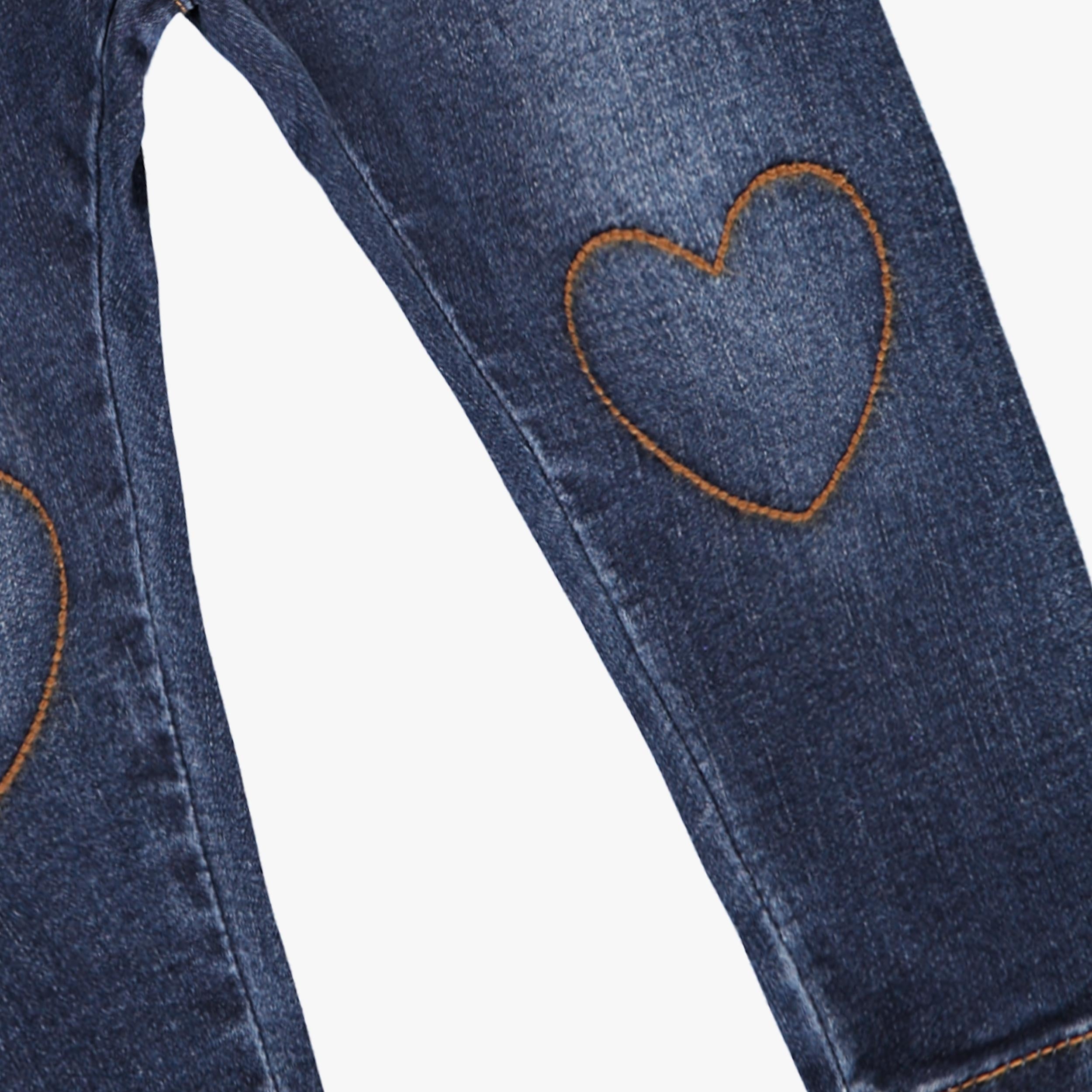 Zoom sur un cœur brodé sur jean bébé fille bleu foncé effet denim
