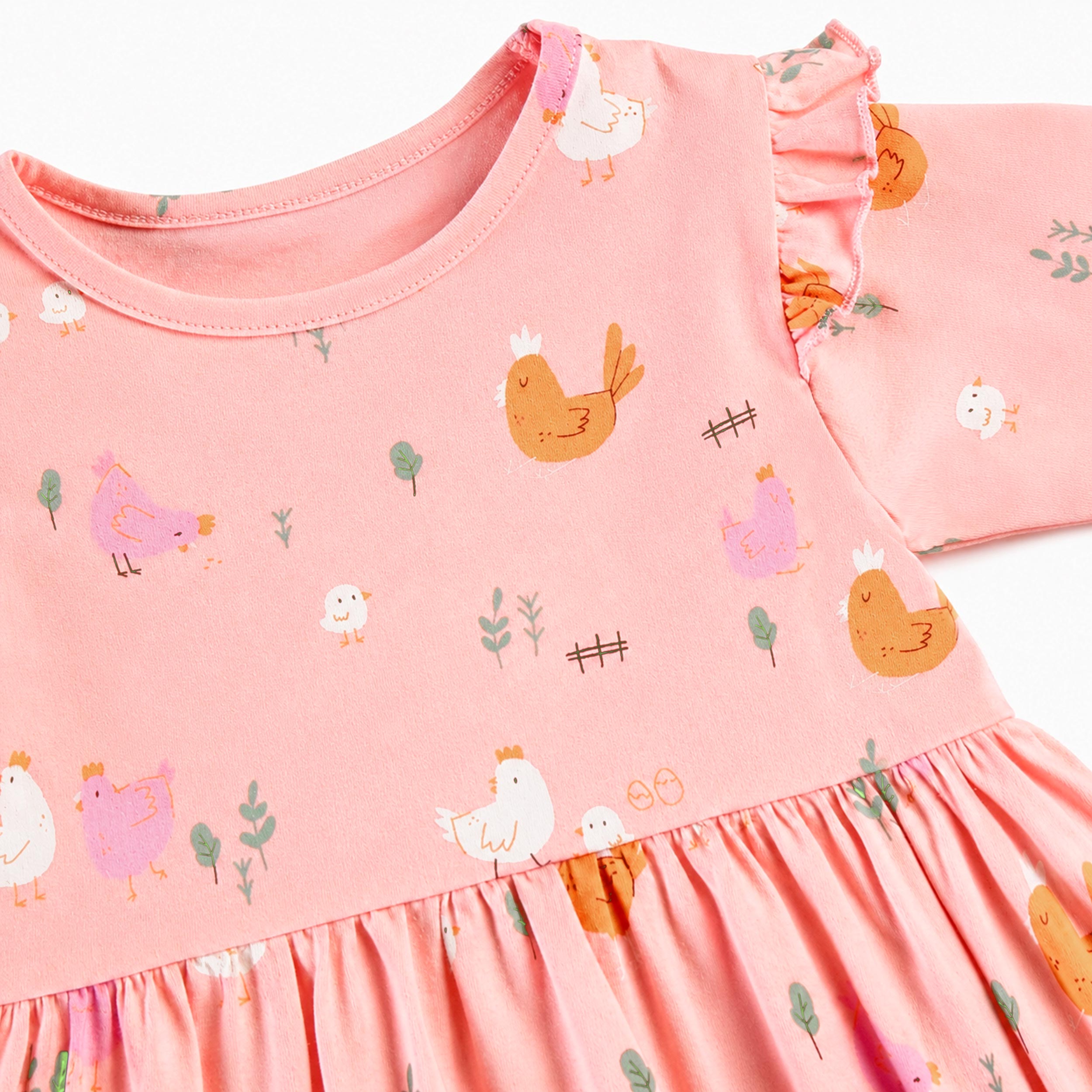 Zoom sur la robe rose bébé avec imprimé poules et volants aux épaules