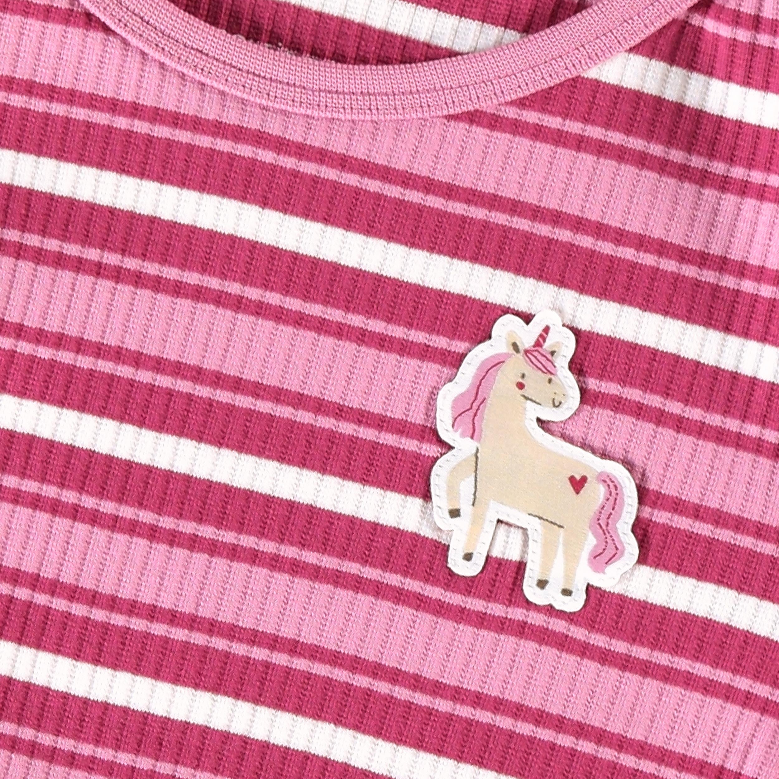 Gros plan de l'écusson licorne sur un pyjama côtelé rose rayé pour fille